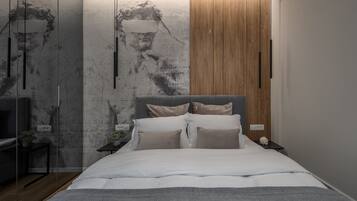A modern bedroom with a large bed, wooden panel wall, and a mural.
