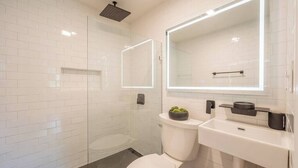 A modern bathroom with a glass-enclosed shower, a toilet, and a sink with a mirror above. - Modern Home 2 Miles to Virginia Tech (Blacksburg)