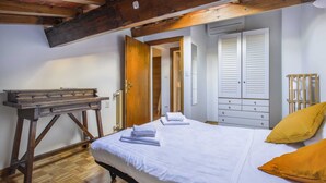 A bedroom with a wooden bed, white bedding, a wooden desk, and a wardrobe with sliding doors. - Florence Apartment (Florence)