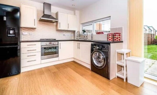 Enjoy cooking in this well-equipped kitchen with a stainless steel oven, dishwasher, and washing machine.