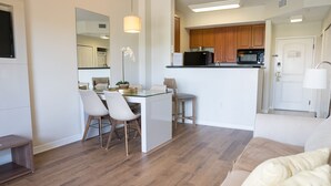 Un appartement moderne comprenant un coin repas, une cuisine et un salon.