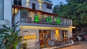 A two-story building with a balcony and a sign that reads "东门园." - Dongmenyuan Inn (Shenzhen)