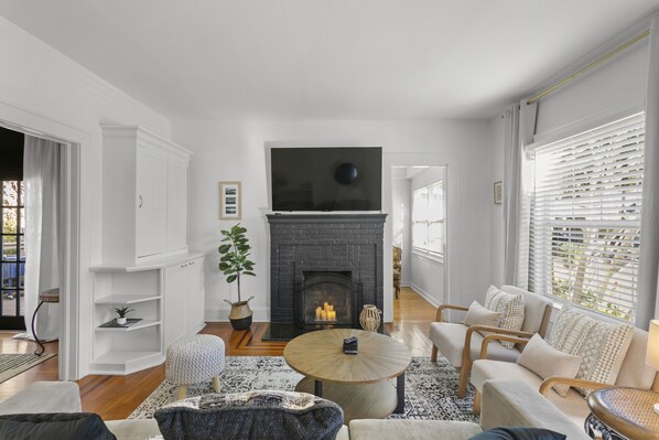 Una sala de estar moderna con chimenea, asientos cómodos y un televisor.