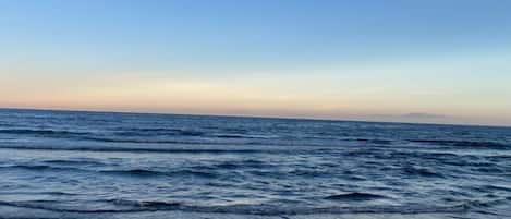Ein Strand mit Wellen und blauem Himmel.