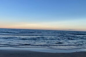 En strand med bølger og en klar himmel.