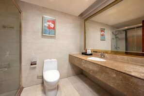 Ein Badezimmer mit Toilette, Waschbecken, einem großen Spiegel und einer Duschkabine.