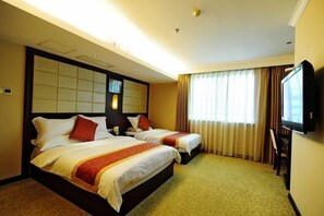Two single beds with matching headboards and a flat-screen TV are featured in this traditional room.