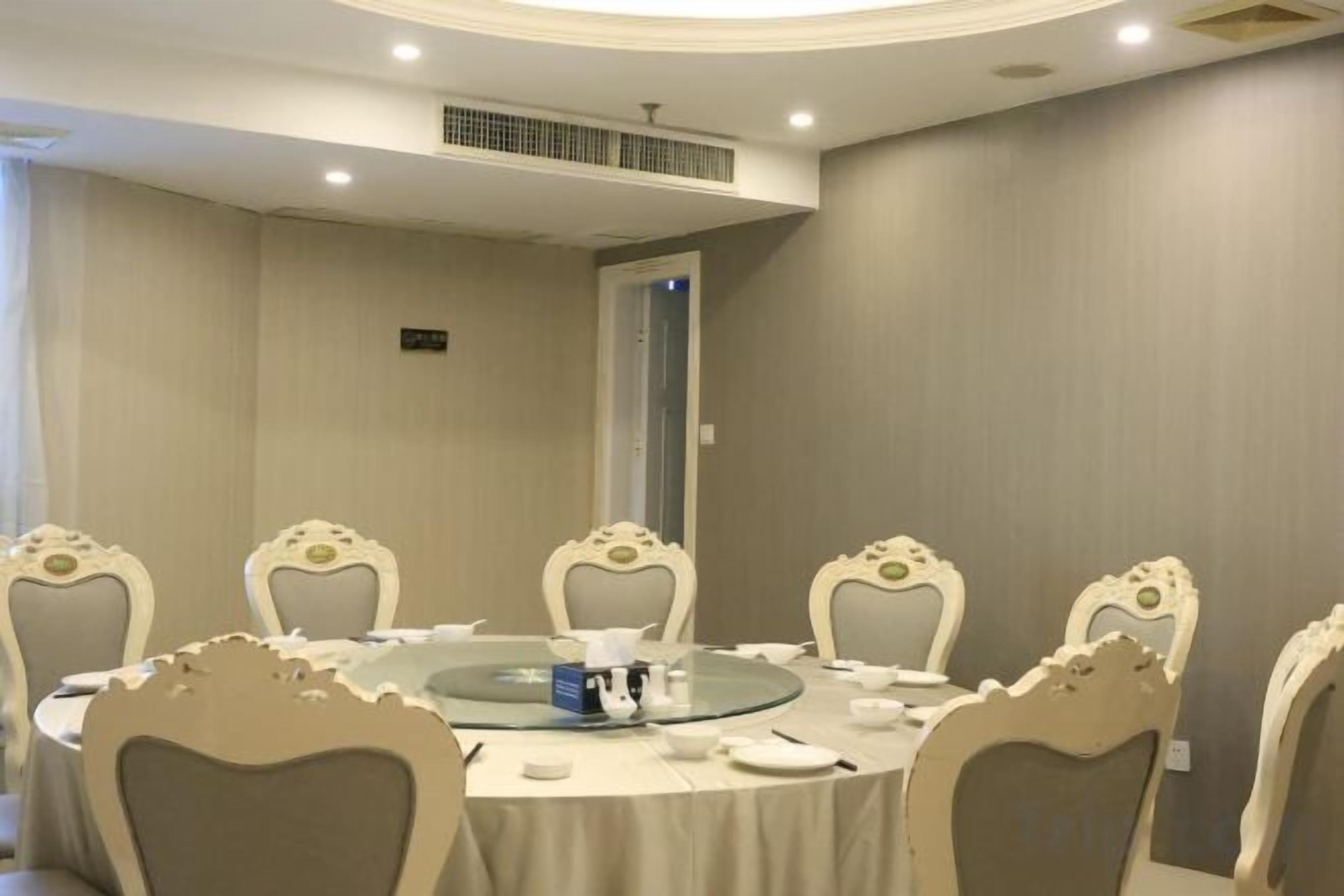 A conference room with a round table, six chairs, and a glass-top table.