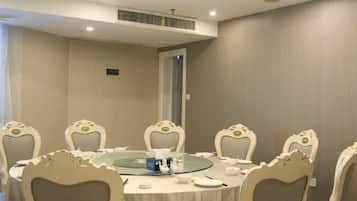 A conference room with a round table, six chairs, and a glass-top table.