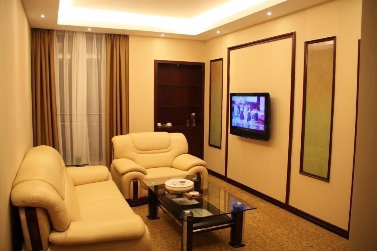 Ein Hotelzimmer mit einer Couch, einem Fernseher und einem Couchtisch.