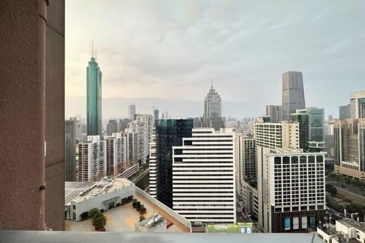 Un paisaje urbano con edificios altos, incluyendo un rascacielos destacado con una cima puntiaguda, y una mezcla de estilos arquitectónicos modernos y antiguos.