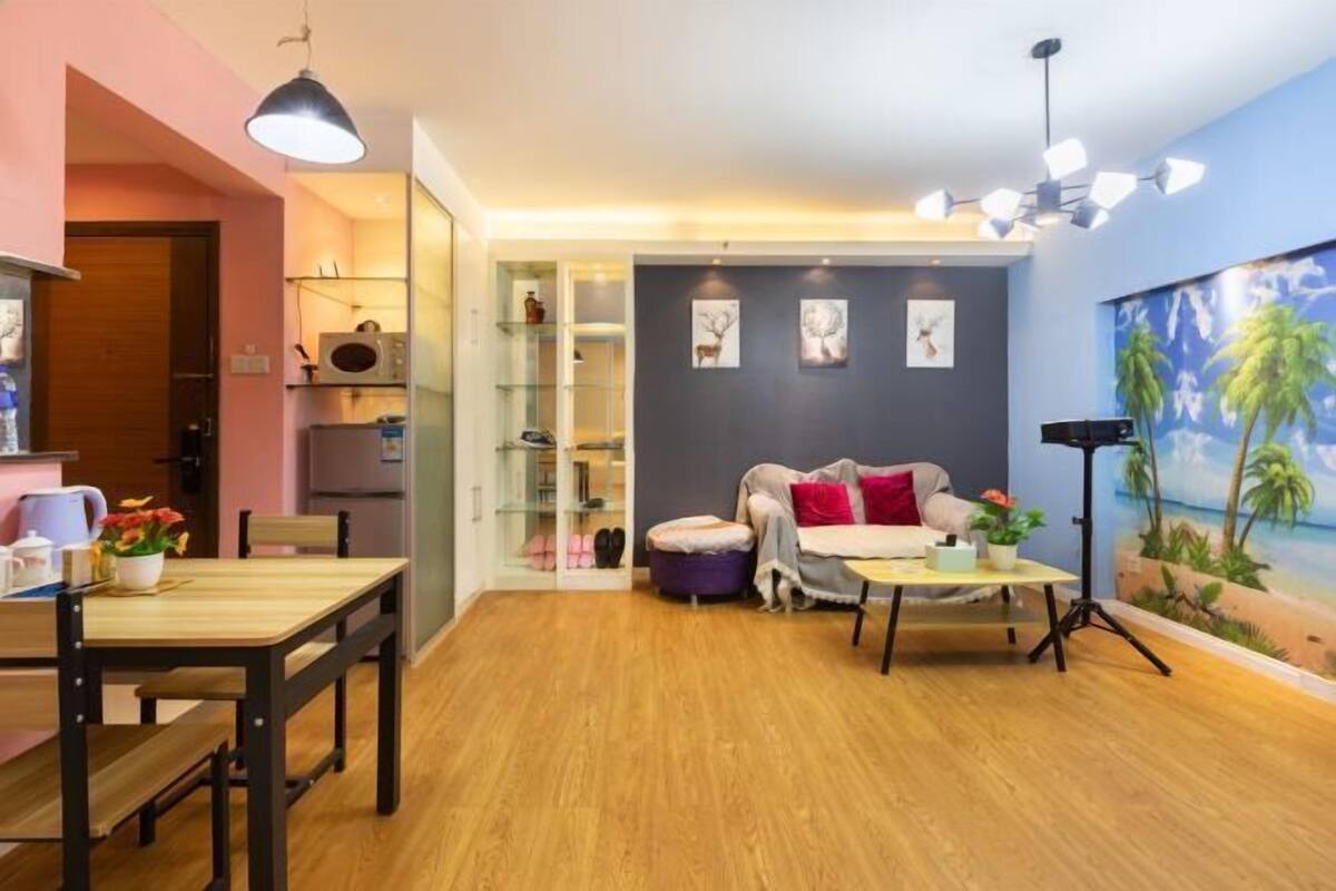 Un salon moderne avec un plancher en bois, un canapé, une table basse et un coin repas comprenant une table et des chaises.