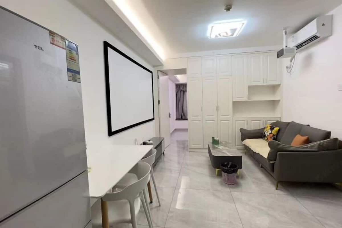 Un espace de vie compact comprenant un coin cuisine, un coin repas et un espace détente avec un canapé et une table basse.