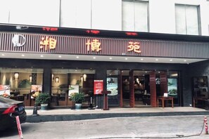 Un restaurante con letrero, mesas al aire libre y una puerta con cadena.
