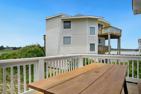 A two-story house with a balcony and a wooden deck.