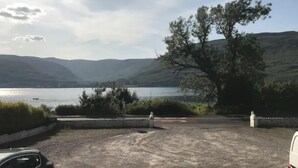 Un estacionamiento con vistas a un lago y colinas.