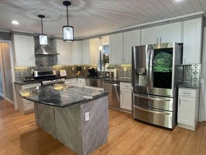 Enjoy cooking in this well-equipped kitchen with a large island, stainless steel appliances, and a microwave.