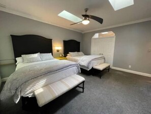 Two single beds with matching headboards and footboards, a bench, and a ceiling fan.