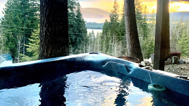 A hot tub under a wooden structure with a view of a forest and mountains. - HOT TUB'n at Shuswap Lake
RnR with MnM in our Pet-Friendly! Lakeview Home (Anglemont)