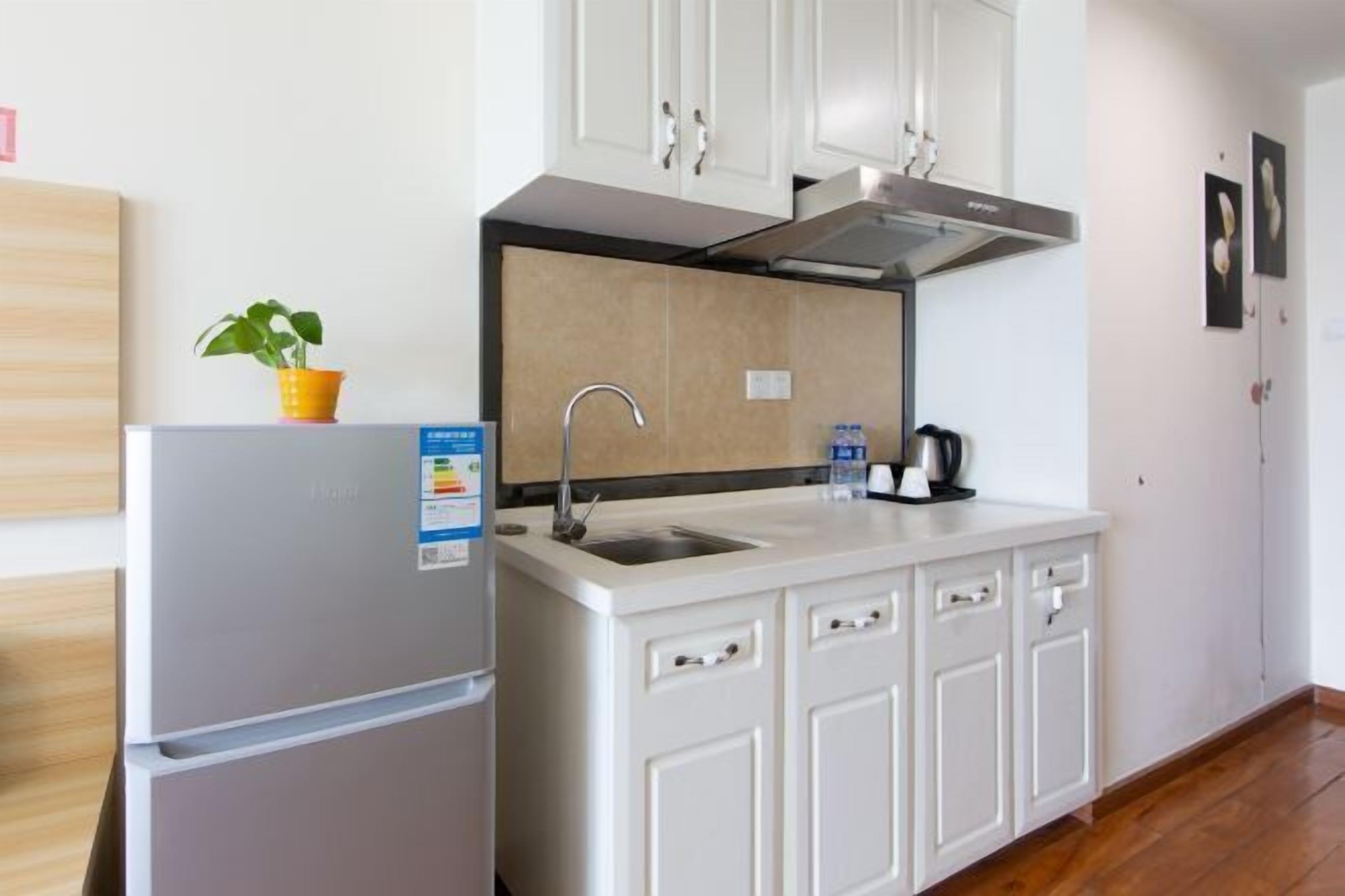 A compact kitchen with a built-in refrigerator, a sink, and a stove.