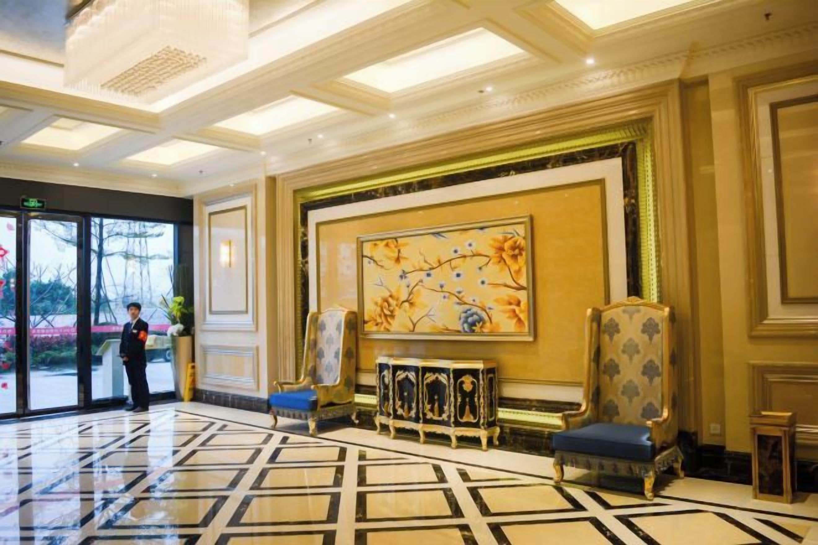 Un hall d’hôtel doté d’une grande entrée, d’un comptoir d’accueil et d’un mur décoratif.