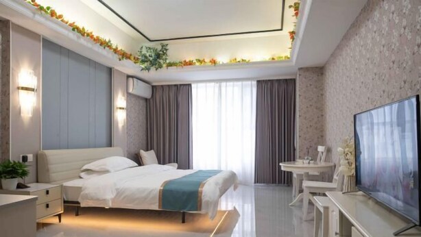 Une chambre d’hôtel moderne équipée d’un lit, de tables de chevet, d’un téléviseur et d’un bureau.
