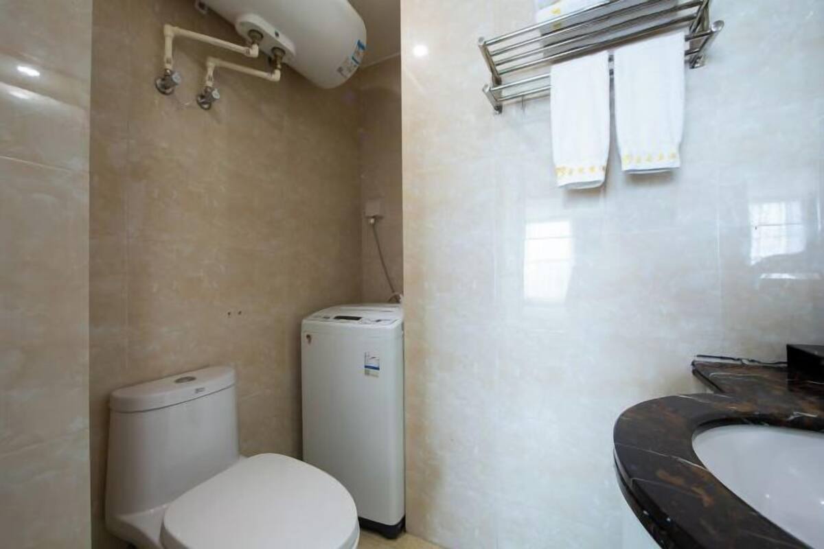 Ein Badezimmer mit Toilette, Waschmaschine und Badewanne.