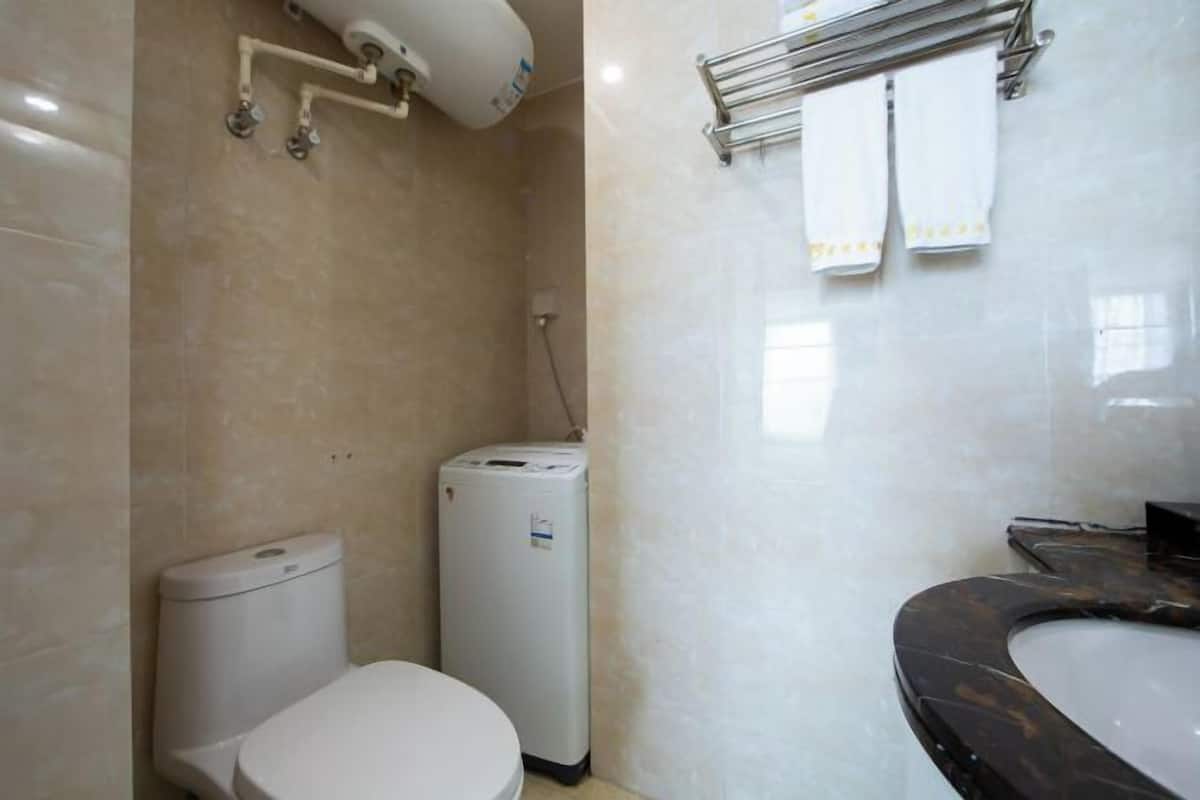 Ein Badezimmer mit Toilette, Waschmaschine und Badewanne.
