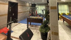 A gym with exercise equipment, a foosball table, and a pool table. - golden comfort (Hafr Al Batin)