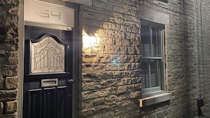 Un bâtiment en pierre avec une porte noire et une fenêtre.