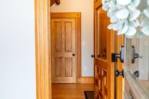 Traditional door with a panel and handle, set within a hallway with wooden flooring.