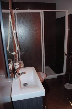 Een douche, handdoeken, toiletpapier