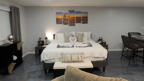 Ein Hotelzimmer mit einem Bett, Nachttischen, einem Schreibtisch und einem Stuhl.