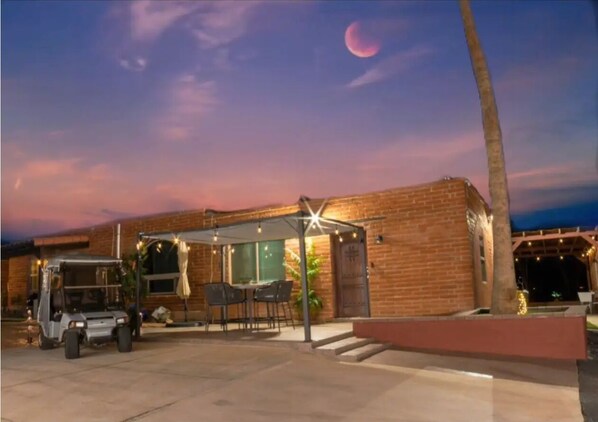 Guests can enjoy a covered outdoor seating area with a palm tree nearby.