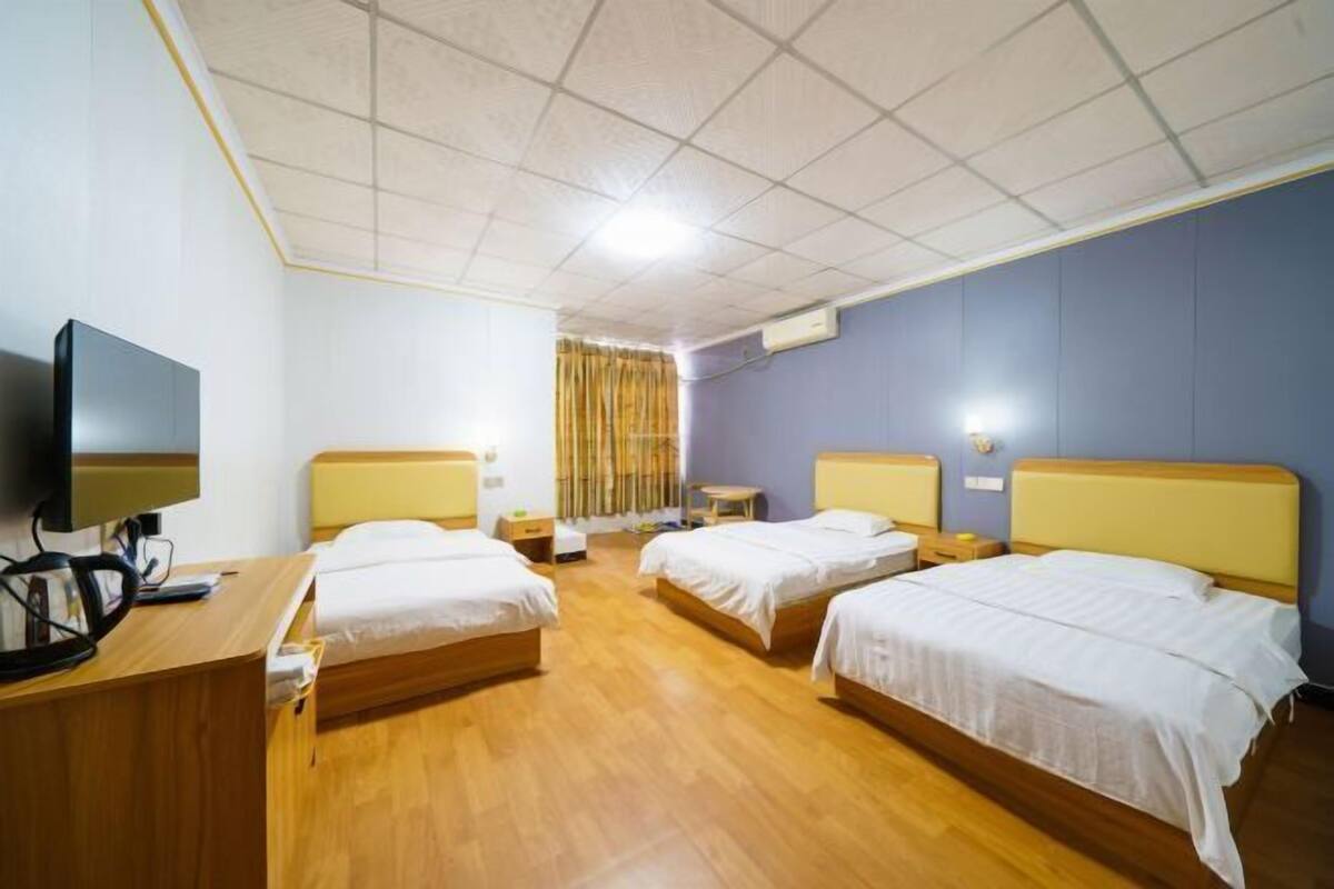 A hotel room with two beds, a desk with a computer, and a television.