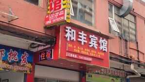 Un hôtel avec une enseigne rouge et un numéro de téléphone.