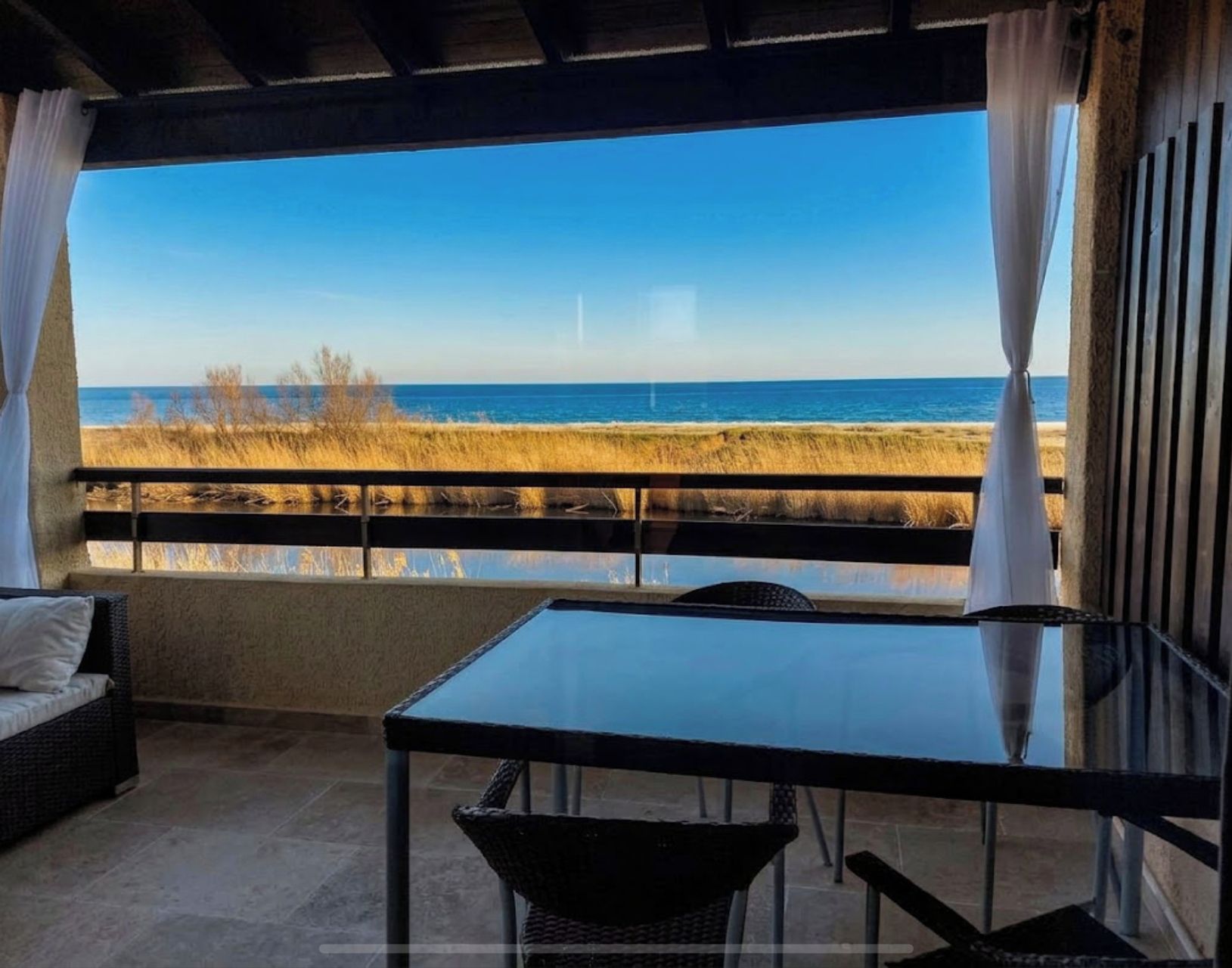 Un balcon avec vue sur la plage et l’océan.