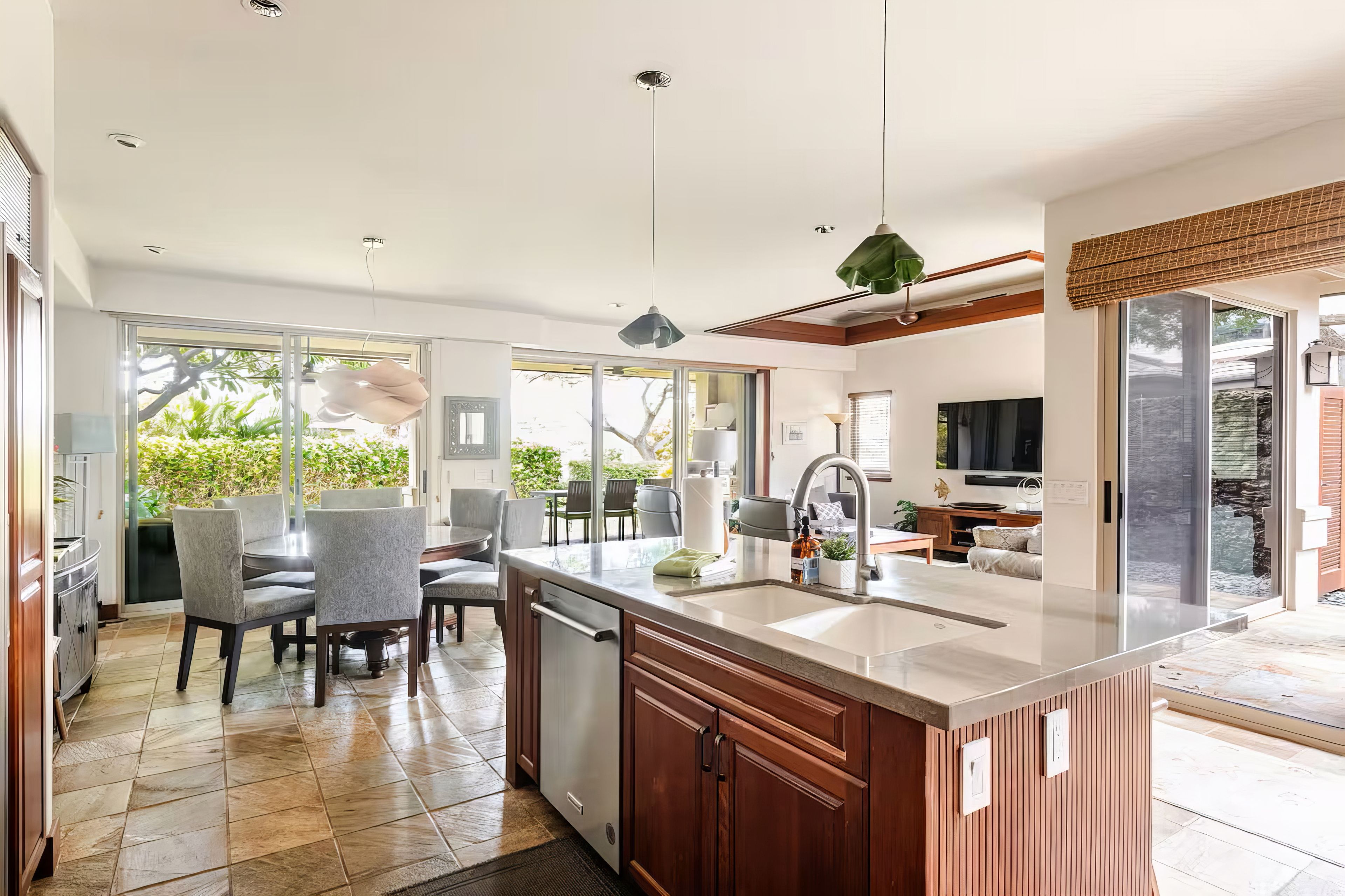A modern kitchen with a large island, built-in appliances, and a dining area with chairs and a table.