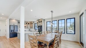 Una cocina amplia con una isla central, una mesa de comedor de madera y sillas.
