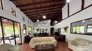 Amplia sala de estar con techo alto, comedor y cocina.
