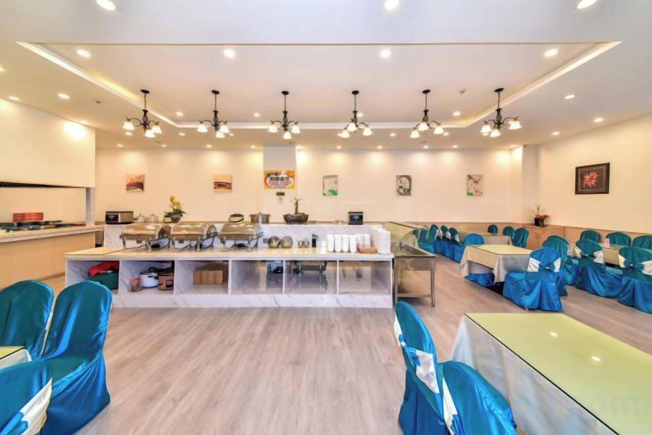 Un salón de conferencias con una larga mesa, sillas y una zona de cocina.
