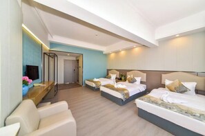 A hotel room with two beds, a desk with a flat-screen TV, and a seating area with a chair. - Shun Xing Hotel (Dali City)