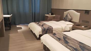 A hotel room with two beds, a desk, and a chair.