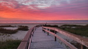 A wooden boardwalk leading to a beach with a sunset in the background. - 6 Bedroom + Crows Nest - Beach View (Galveston)