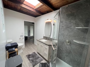 Une salle de bain moderne équipée d’une douche, de toilettes et d’un lavabo.