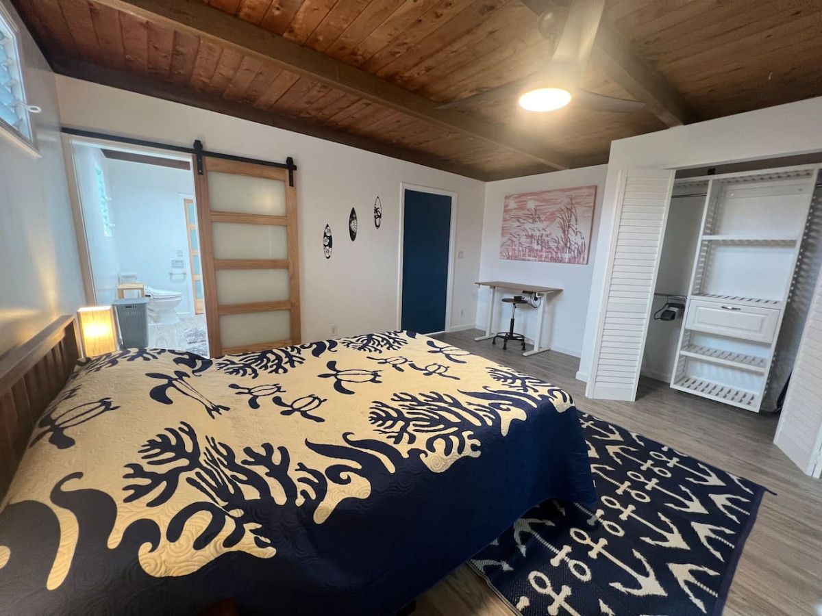 A bedroom with a bed, a wardrobe, and a desk.