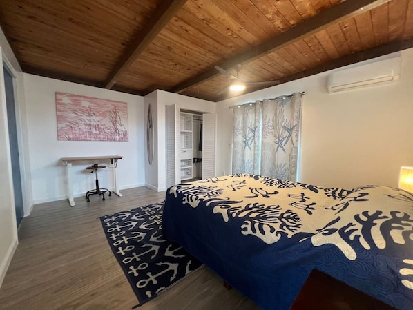 Une chambre à coucher avec un lit, une petite table, une chaise et une armoire.