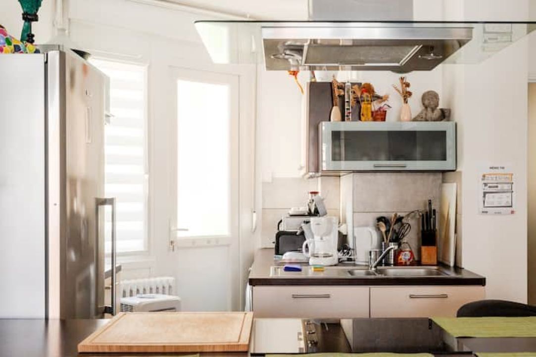 Une cuisine compacte équipée d’un four à micro-ondes, d’une machine à café et d’un petit plan de travail.
