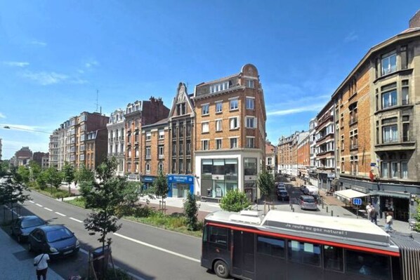 A street view with a bus, buildings, and a clear sky.