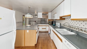 A kitchen with white cabinets, a wooden island, a sink, and a stove. - Spacious Country Home & 15 minutes from Lake Michigan
 (Grand Junction)